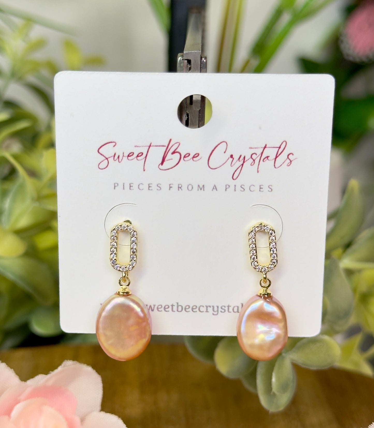 Peach color baroque pearl drop earrings with silicon backs. 18k Gold plated stainless steel with cubic zirconia accent stones.